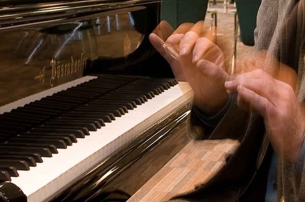 Poster Musicologist Uwe Kliemt at keyboard.