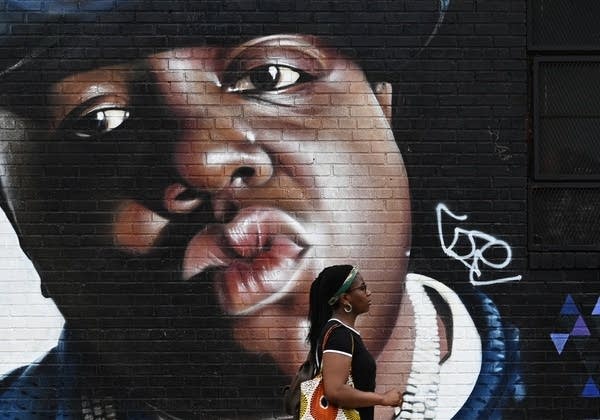 Poster A woman walks past the Sipros mural of the rapper Biggie Smalls 