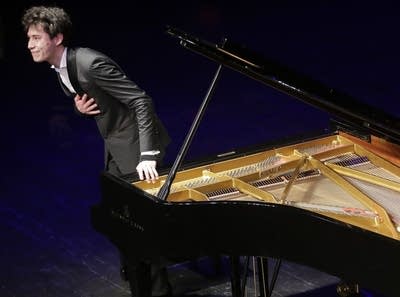 A pianist takes a bow after an onstage performance