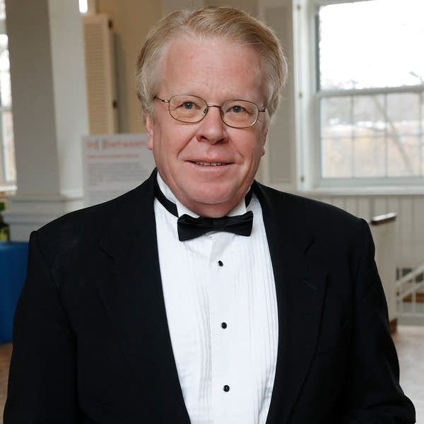 A portrait of a man in a dinner jacket in a concert hall