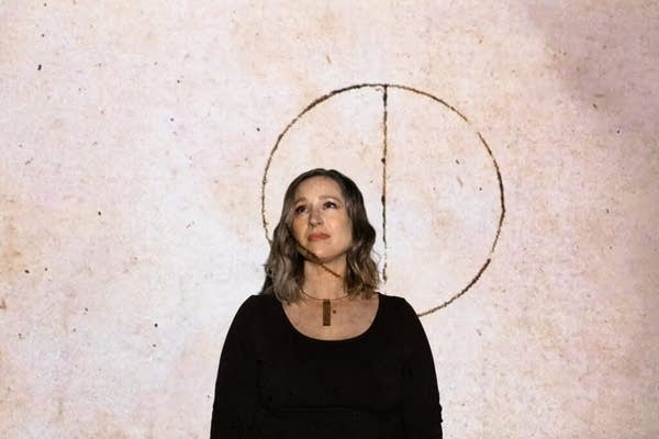 Poster A woman stands in a projection of a circle