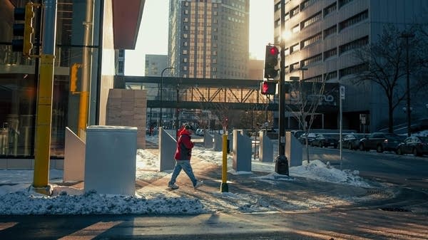 Poster A man walks on the snow-covered sidewalks in downtown Minneapolis.
