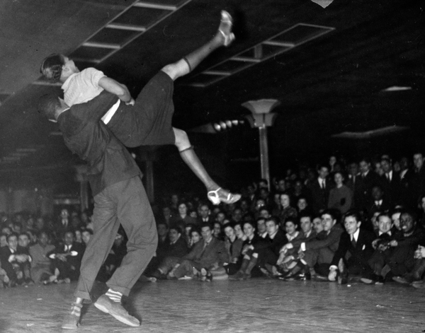 Couple competing in Savoy Ballroom Lindy Hop contest as crowd looks on in 1938.