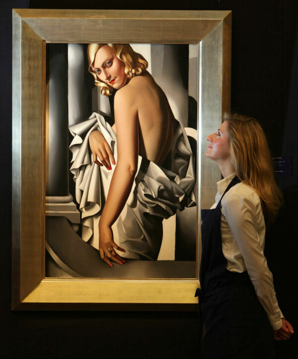 A gallery technician at Sotheby's auction house admires a painting by Tamara de Lempicka in 2009 entitled Portrait de Marjorie Ferry from 1932.